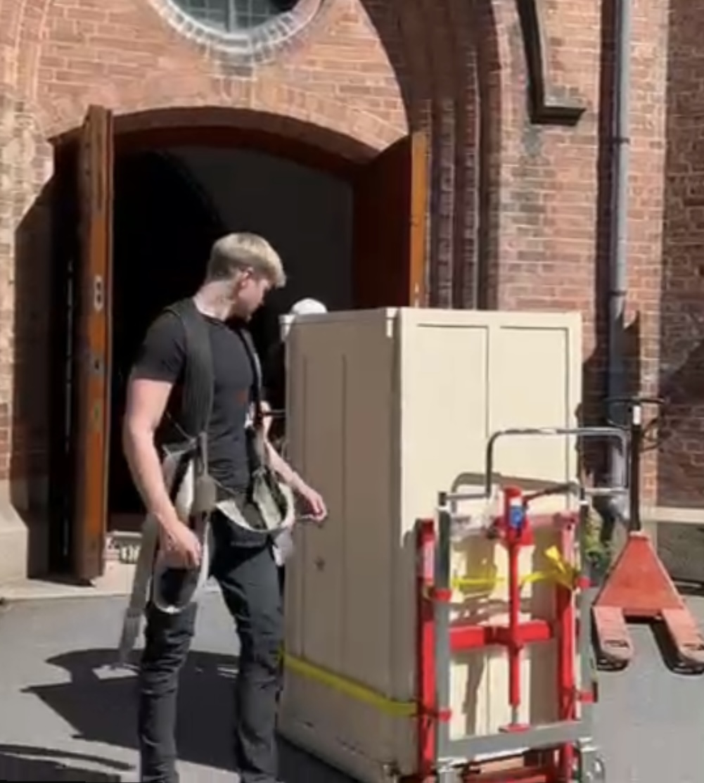 Flyttemann med bæresele håndterer safe på spesialtralle