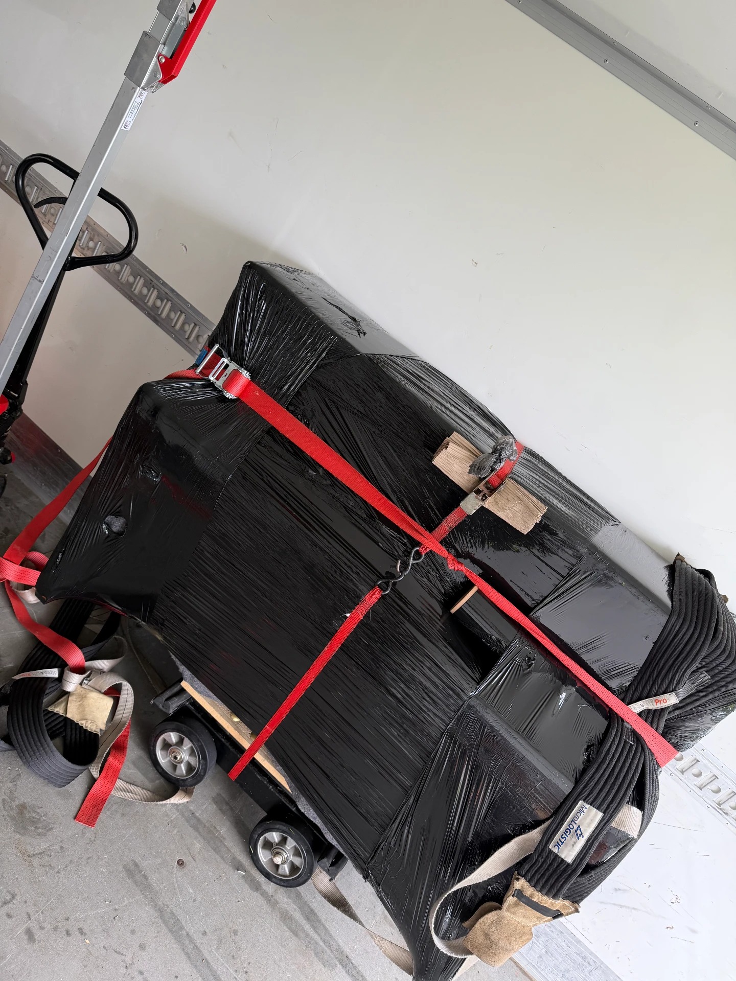 Innpakket piano sikret med stropper i flyttebil